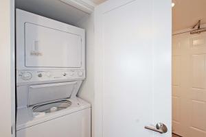 a white washer and dryer in a room with a door at One Seagrove Place 0205 in Santa Rosa Beach