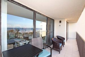 a balcony with a table and chairs and a view of the ocean at One Seagrove Place 0205 in Santa Rosa Beach