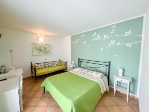 a bedroom with a green bed and a blue wall at B&B Il Grande Salice Bike Friends in Ponti Sul Mincio