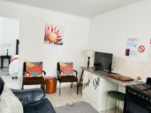 a living room with a table with a laptop on a counter at Covenant Place in Cape Town