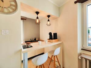 a kitchen with two white chairs and a counter at Le repère des amis - 4 pers - proche tram - parking gratuit - babyfoot in Lingolsheim