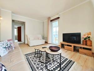 a living room with a couch and a tv at Le repère des amis - 4 pers - proche tram - parking gratuit - babyfoot in Lingolsheim