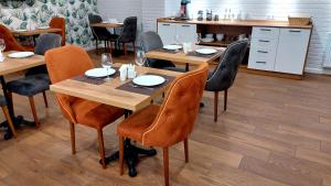 ein Esszimmer mit Holztischen und Stühlen in der Unterkunft Falcon Hotel in Tbilisi City