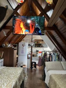 a room with a flat screen tv on the ceiling at Canto Gira Sol - Estúdio Borboleta in Penha +3 photos