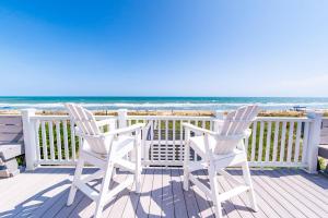 two white chairs sitting on a deck overlooking the ocean at T.L. Sea - KDH MP 6, Oceanfront, Ocean view, Rec Room, Spacious Decks, Private Walk to Beach in Kill Devil Hills