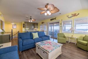 a living room with a blue couch and chairs at T.L. Sea - KDH MP 6, Oceanfront, Ocean view, Rec Room, Spacious Decks, Private Walk to Beach in Kill Devil Hills +63 photos
