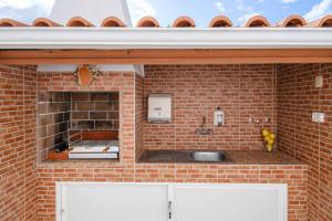 a kitchen with a brick wall and a sink at Casa dos Andrades in Sesimbra +28 photos