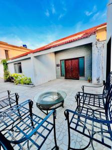 a patio with two chairs and a table in front of a building at Waves Guest House Clifton Khi in Karachi
