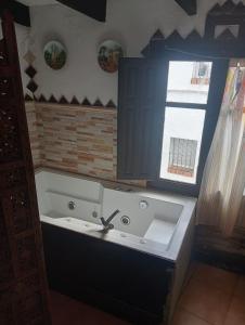a bathroom with a bath tub and a window at Casa rural las conchas in Cazalla de la Sierra