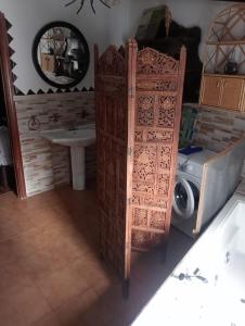 a bathroom with a wooden door next to a washing machine at Casa rural las conchas in Cazalla de la Sierra