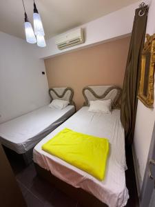 two beds in a small room with yellow sheets at بورتو سخنه in Ain Sokhna +113 photos