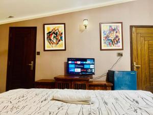 a bedroom with a bed and a flat screen tv at Waves Guest House Clifton Khi in Karachi