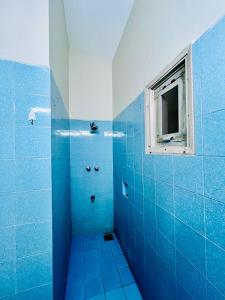 a blue tiled shower with a window in a bathroom at Waves Guest House Clifton Khi in Karachi +69 photos