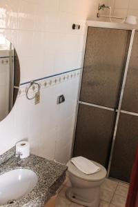 a bathroom with a toilet and a sink and a shower at Niv's Hotel in Monte Sião +24 photos