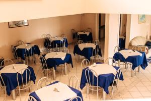 a room with blue and white tables and chairs at Niv's Hotel in Monte Sião