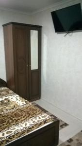 um quarto com uma cama e uma porta de madeira em Uyutny Dom em Vardane