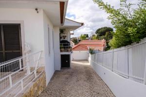 a white house with a hallway leading to a driveway at Casa dos Andrades in Sesimbra