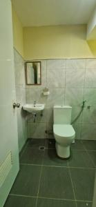 a bathroom with a toilet and a sink at Wengsmont in Tubod