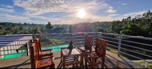 two chairs and a table on a balcony with a view at Wengsmont in Tubod