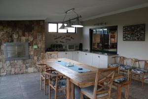 a kitchen with a large wooden table and chairs at Highland Gate Golf & Trout Estate, House 925 in Dullstroom