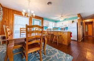 a dining room and kitchen with a table and chairs at Serendipity - KDH MP 6.5, Oceanfront, Amazing Ocean View, Hot Tub, Pets OK, YR Flex Stays in Kill Devil Hills