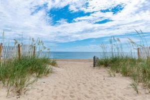 a sandy beach with a fence and the ocean at Serendipity - KDH MP 6.5, Oceanfront, Amazing Ocean View, Hot Tub, Pets OK, YR Flex Stays in Kill Devil Hills