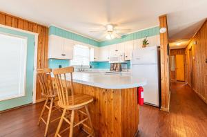 a kitchen with a counter and a refrigerator at Serendipity - KDH MP 6.5, Oceanfront, Amazing Ocean View, Hot Tub, Pets OK, YR Flex Stays in Kill Devil Hills +29 photos