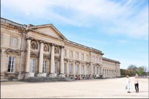 two people walking in front of a large building at Le Napoléon in Compiègne