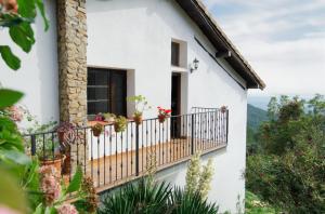 a white house with a balcony with flowers at Casa Rural Arbillas in Arenas de San Pedro +16 photos