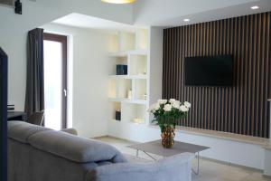 a living room with a couch and a vase of flowers at Agriturismo La Vecchia Torre in San Nicola Manfredi