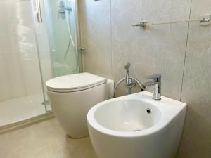 a bathroom with a sink and a toilet and a shower at Sea Apartment - Torre Pali in Torre Pali +15 photos