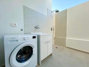 a washing machine in a bathroom with a sink at Sea Apartment - Torre Pali in Torre Pali