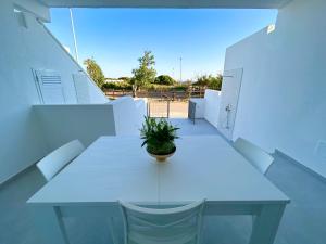 a white table with a potted plant on top of it at Sea Apartment - Torre Pali in Torre Pali