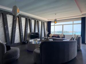 a living room with couches and a tv and a large window at شاليه درة العروس in Durat Alarous