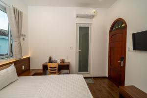 a bedroom with a bed and a table and a door at Hotel Thanh Van 2 in Tuy Hoa