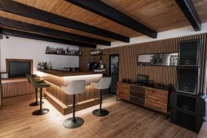 eine Bar mit zwei Stühlen und einem Tresen mit einem Fernseher in der Unterkunft Alter Ego in Valea Drăganului
