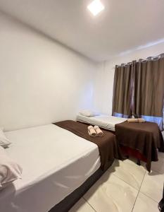 two twin beds in a room with two towels on them at Berenice Concept Residence - By Temporada Expert in Feira de Santana