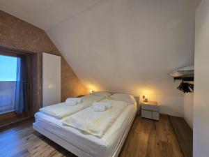 a large white bed in a room with a window at Corte Cimiotti - Borgo Gortani in Sùtrio