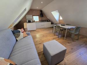 a living room with a couch and a table and a kitchen at Corte Cimiotti - Borgo Gortani in Sùtrio