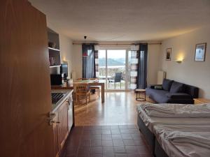 a living room with a bed and a kitchen with a couch at Apartmentanlage am Kellerberg in Zandt