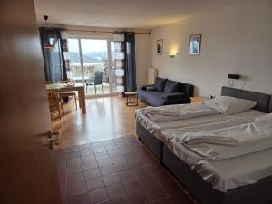 a bedroom with a bed and a living room at Apartmentanlage am Kellerberg in Zandt