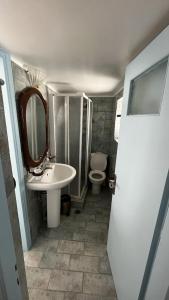 a bathroom with a sink and a toilet and a mirror at Camaraki Capitano House , Chora Serifos in Serifos Chora +4 photos
