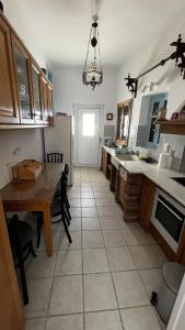 a kitchen with a table and a refrigerator at Camaraki Capitano House , Chora Serifos in Serifos Chora