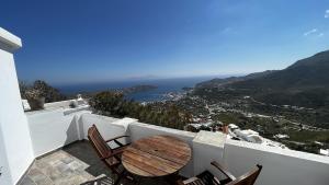 a table and chairs on a balcony with a view at Camaraki Capitano House , Chora Serifos in Serifos Chora