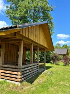 a large wooden building with a solar roof at Kempings Paegļi in Kaijciems