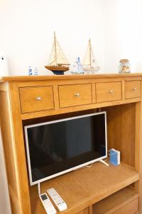 a wooden dresser with a tv with two boats on it at Cala Rajá 5 in La Isleta del Moro