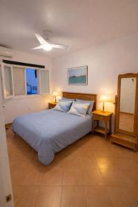 a bedroom with a bed with two lamps and a mirror at Cala Rajá 5 in La Isleta del Moro