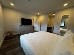 a bedroom with a bed and a flat screen tv at Xquisite Suites in Freeport