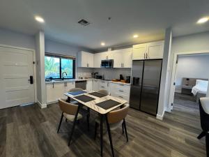 a kitchen with white cabinets and a table and chairs at Xquisite Suites in Freeport