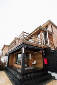 ein Haus mit einer Terrasse, vor der ein Stuhl steht in der Unterkunft Alter Ego in Valea Drăganului